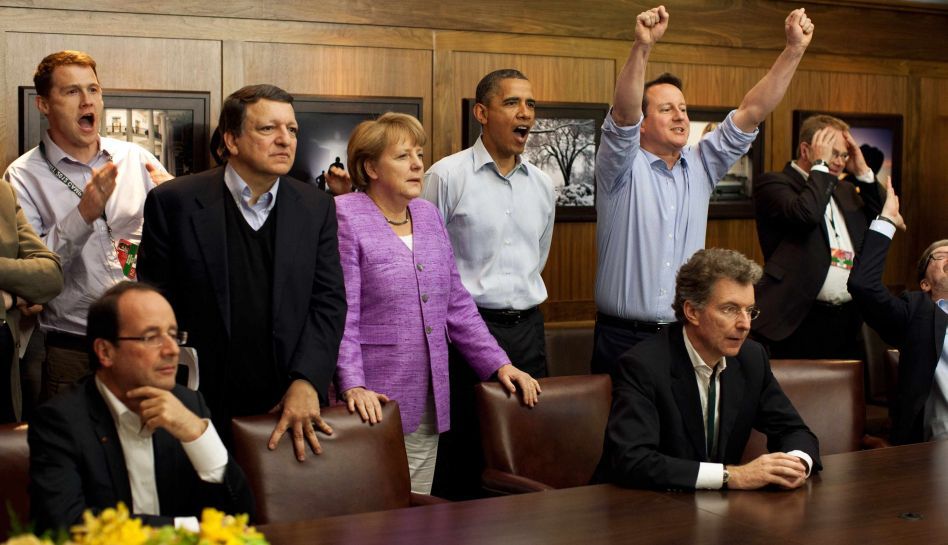 Prime Minister David Cameron of the United Kingdom, President Barack Obama, Chancellor Angela Merkel of Germany, Jose Manuel Barroso, President of the European Commission, (centre L-R) and others watch the overtime shootout of the Chelsea vs. Bayern Munich Champions League final in the Laurel Cabin conference room during the G8 Summit at Camp David, Maryland, May 19, 2012. REUTERS/White House/ Pete Souza/POOL (UNITED STATES - Tags: POLITICS SPORT SOCCER)